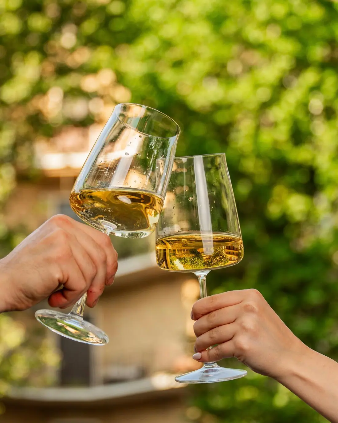 Brindisi con due calici di vino bianco in piazza ai Parioli